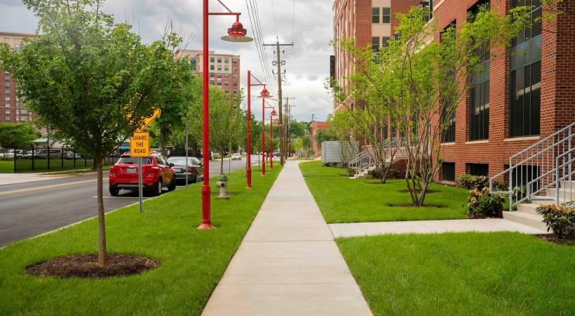 spacious sidewalk and green turf and nearness to buildings